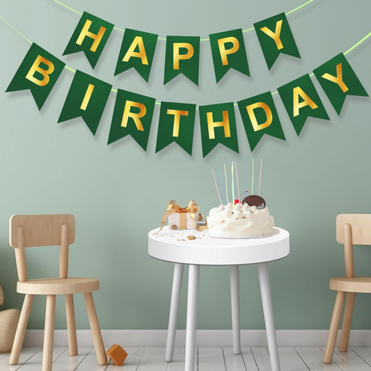 Green and gold 'Happy Birthday' banner above a small round table with a cake and decor items.