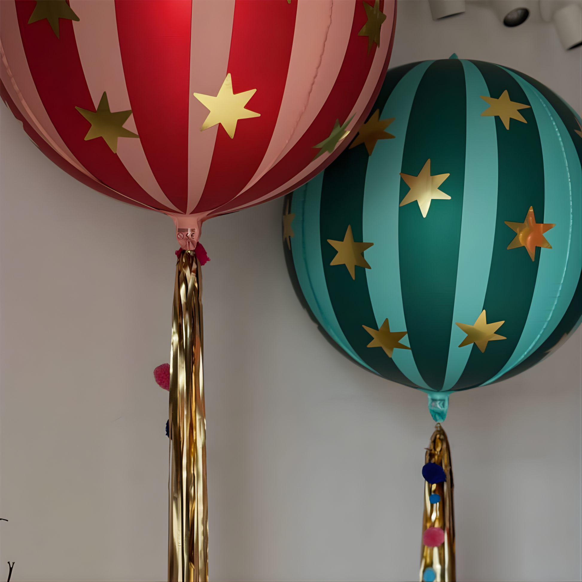 Two colorful paper lanterns with star patterns on a plain background