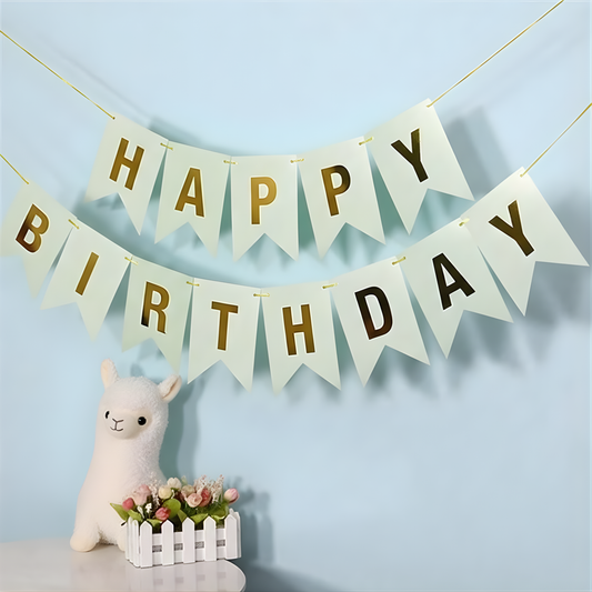Happy Birthday banner with gold text on a light blue background, featuring a small white llama figurine and flower basket.