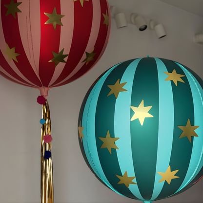 Two decorative balloons with star patterns on a plain background