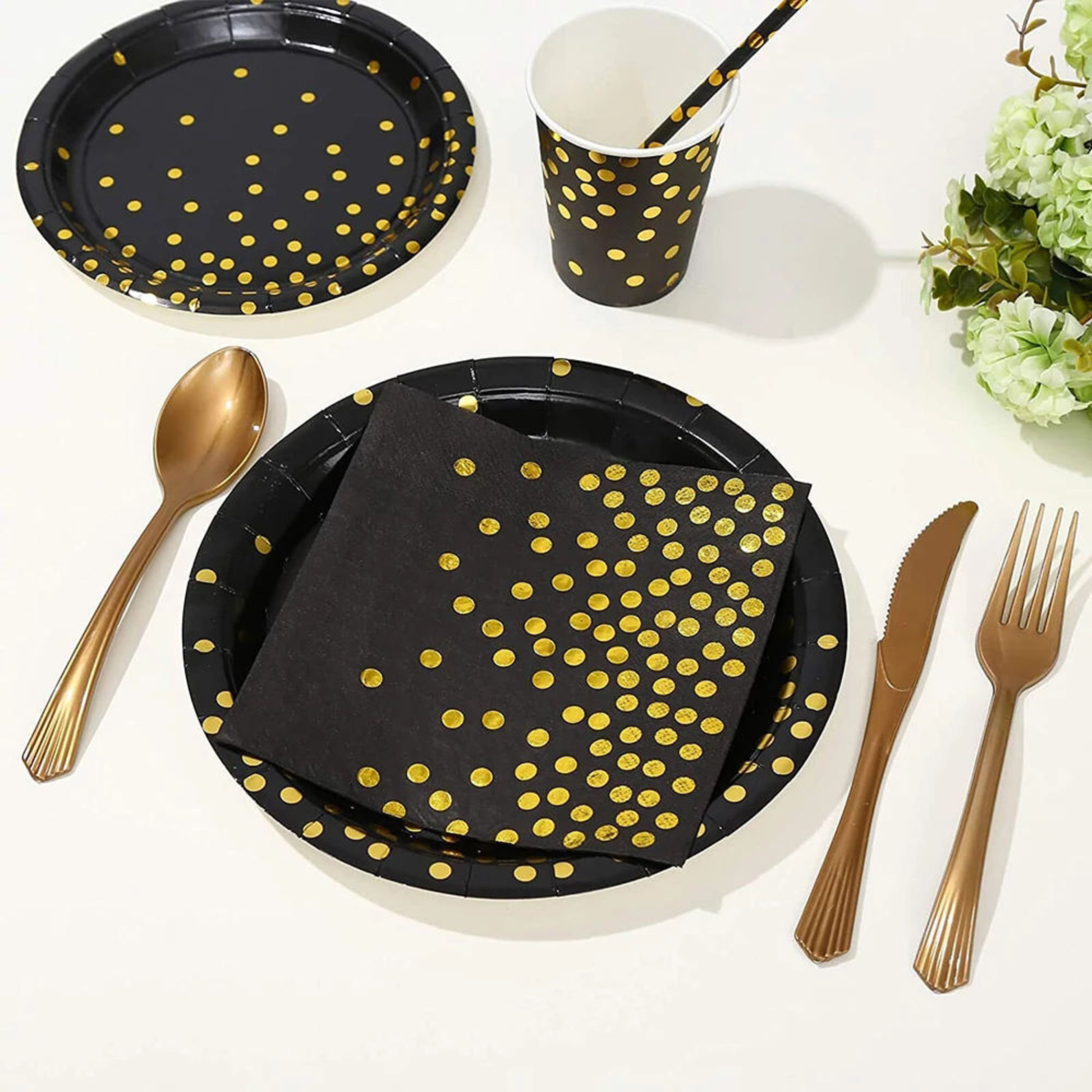 Elegant black and gold birthday party table setup featuring polka dot disposable paper plates, cups, napkins, gold foil accents, and matching cutlery on a white surface — luxurious disposable dinnerware for birthday, wedding, or glamorous events.