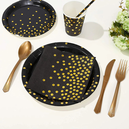 Elegant black and gold birthday party table setup featuring polka dot disposable paper plates, cups, napkins, gold foil accents, and matching cutlery on a white surface — luxurious disposable dinnerware for birthday, wedding, or glamorous events.