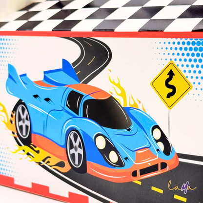 A close-up detail shot of the blue sports car illustration on the front of a party favor box, including a winding road sign.