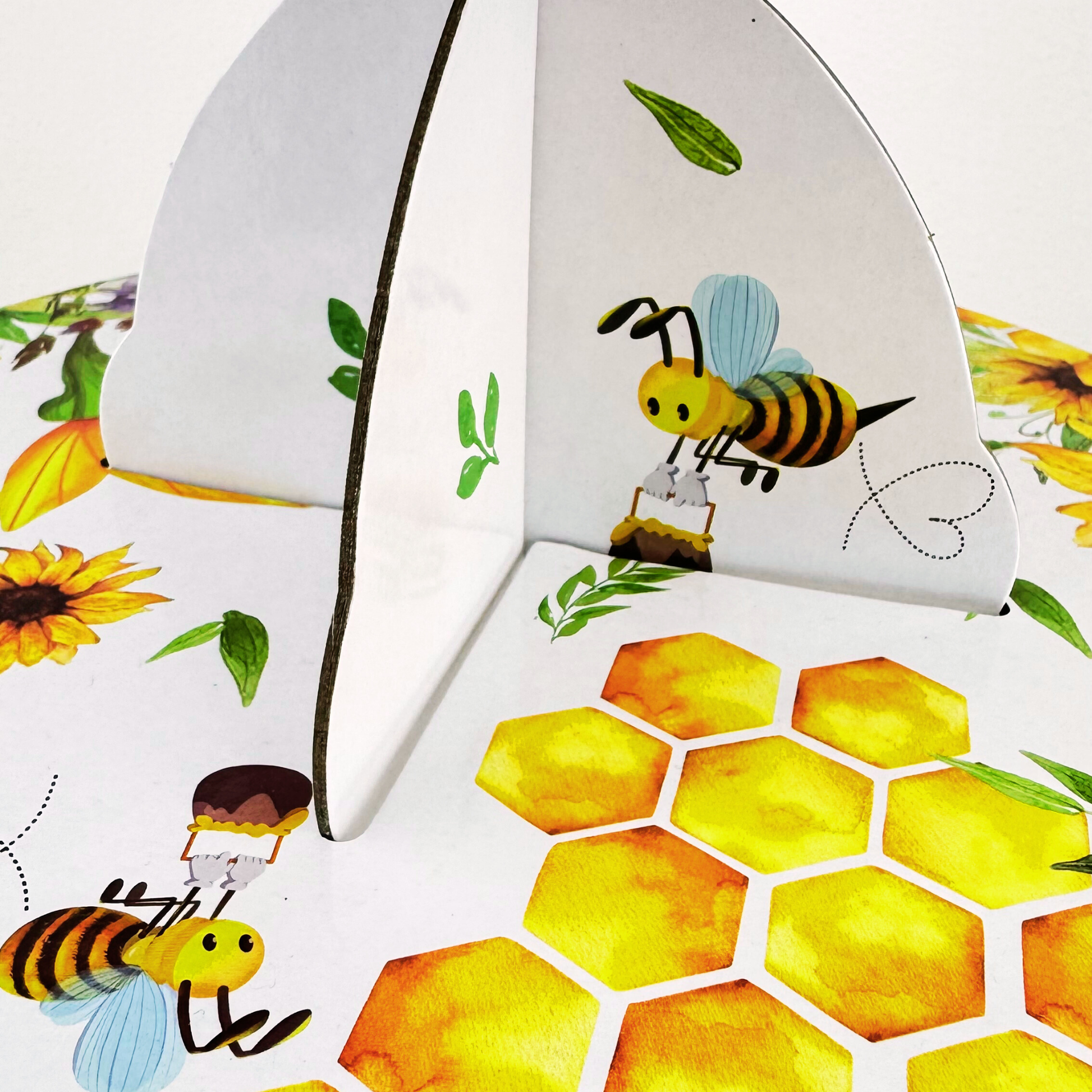 Macro detail of the high-quality honeycomb and bee pattern print on the cupcake stand, showing the interlocking cardboard structure.