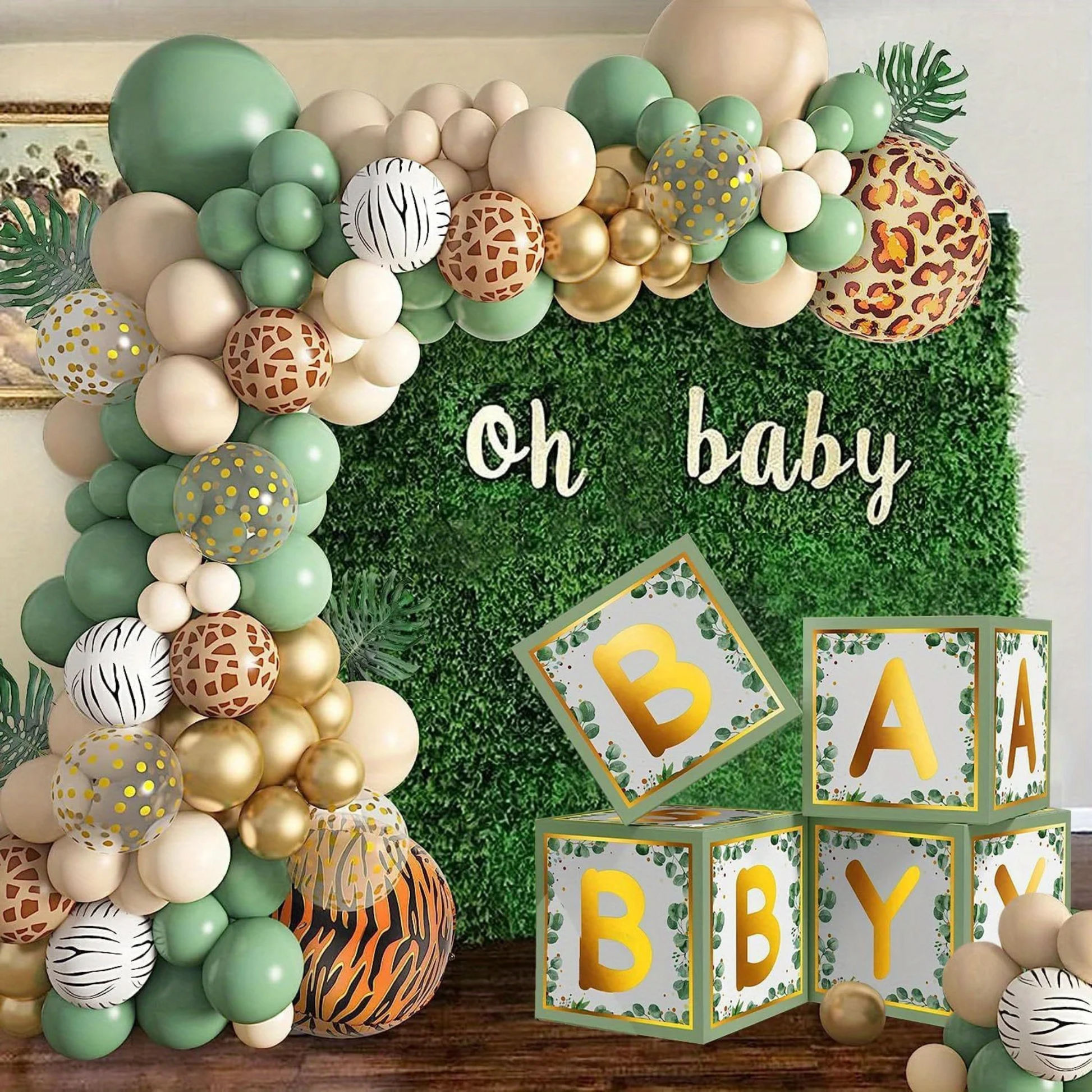 Beautiful completed safari jungle balloon garland arch with "oh baby" sign on a lush green foliage backdrop, featuring clusters of green, beige, gold balloons mixed with tiger, leopard, zebra, and giraffe prints, plus baby blocks for an adorable wild theme baby shower setup.