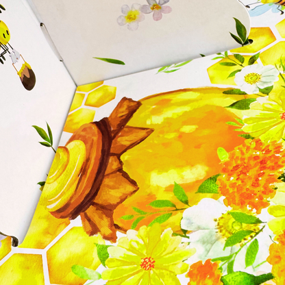 A macro close-up of the cupcake stand's bottom tier, highlighting the yellow honeycomb pattern, flowers, and tiny bee illustration