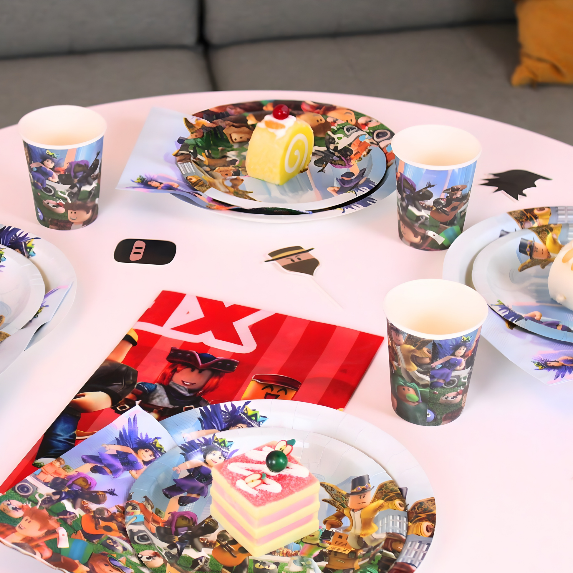 Roblox themed party supplies including plates and cups on a white table setting.