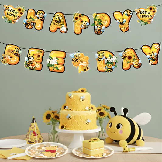 Honeybee-themed party decorations bundle. Includes a "Happy Bee Day" hanging banner, decorative Winnie the Pooh dessert plates with a honeycomb pattern, a matching party hat, and a yellow birthday cake on a white table.